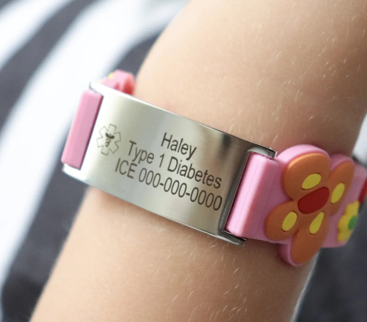 A child wearing a pink silicone medical ID bracelet engraved Haley, Type 1 Diabetes and an ICE number